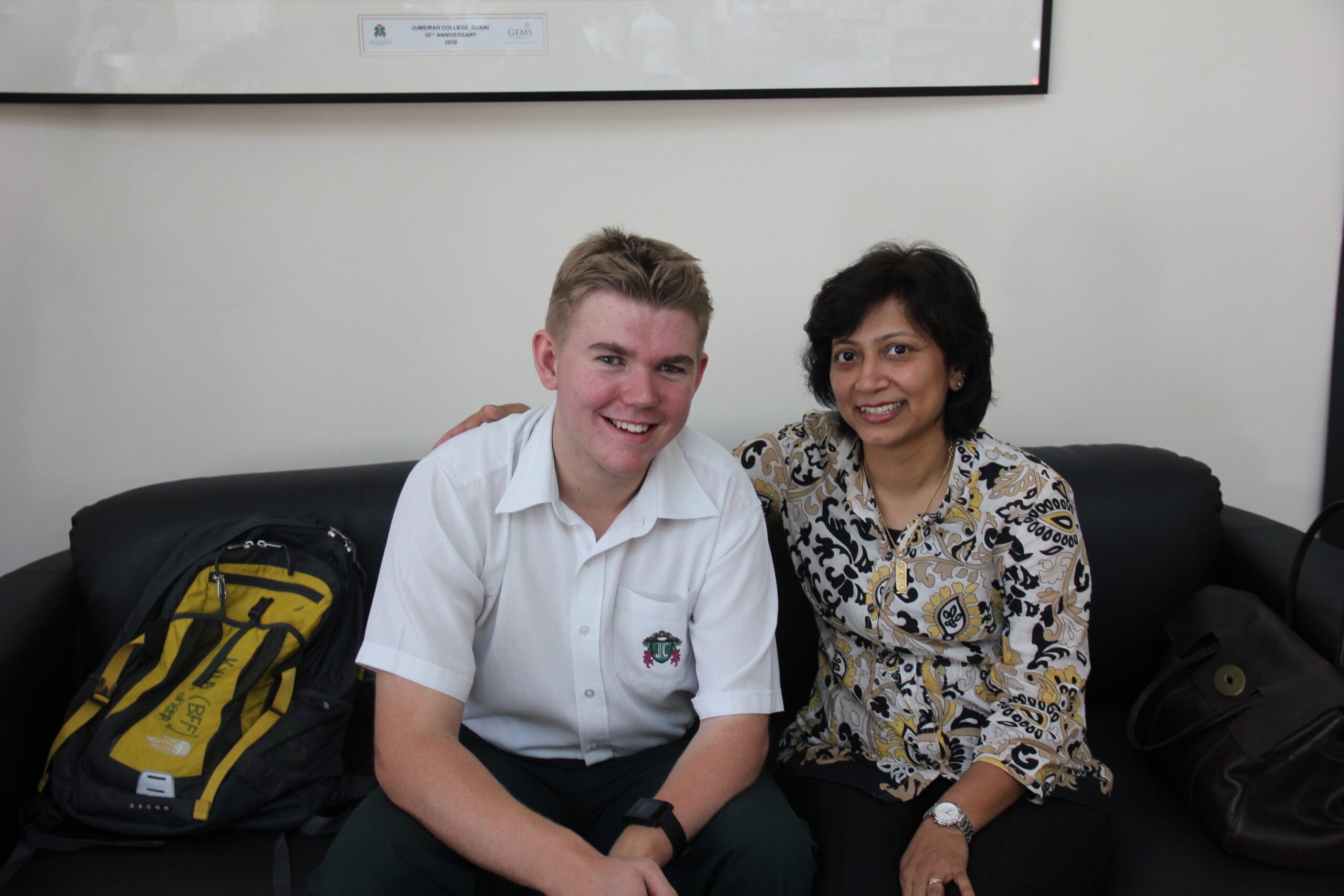 Jake, wearing his school uniform, sits beside Shireen, his special needs assistant at secondary school.