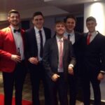 Jake standing with four friends at a formal event.