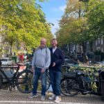 Jake Jones standing with his dad on a canal bridge during a day out in Amsterdam.